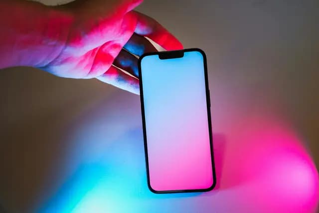 Person texting on a phone late at night, illuminated by phone screen light